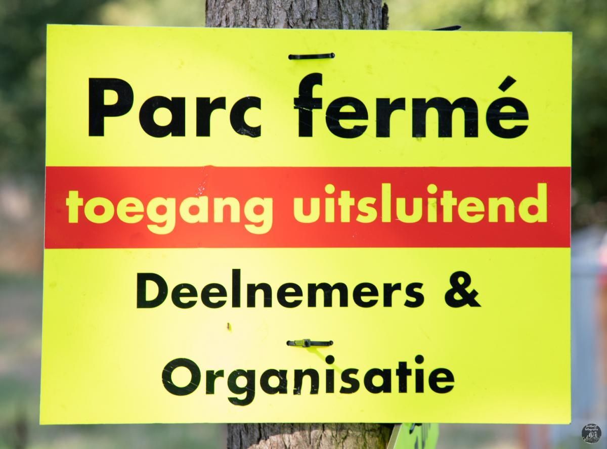 Een geel bord met de tekst parc ferme erop