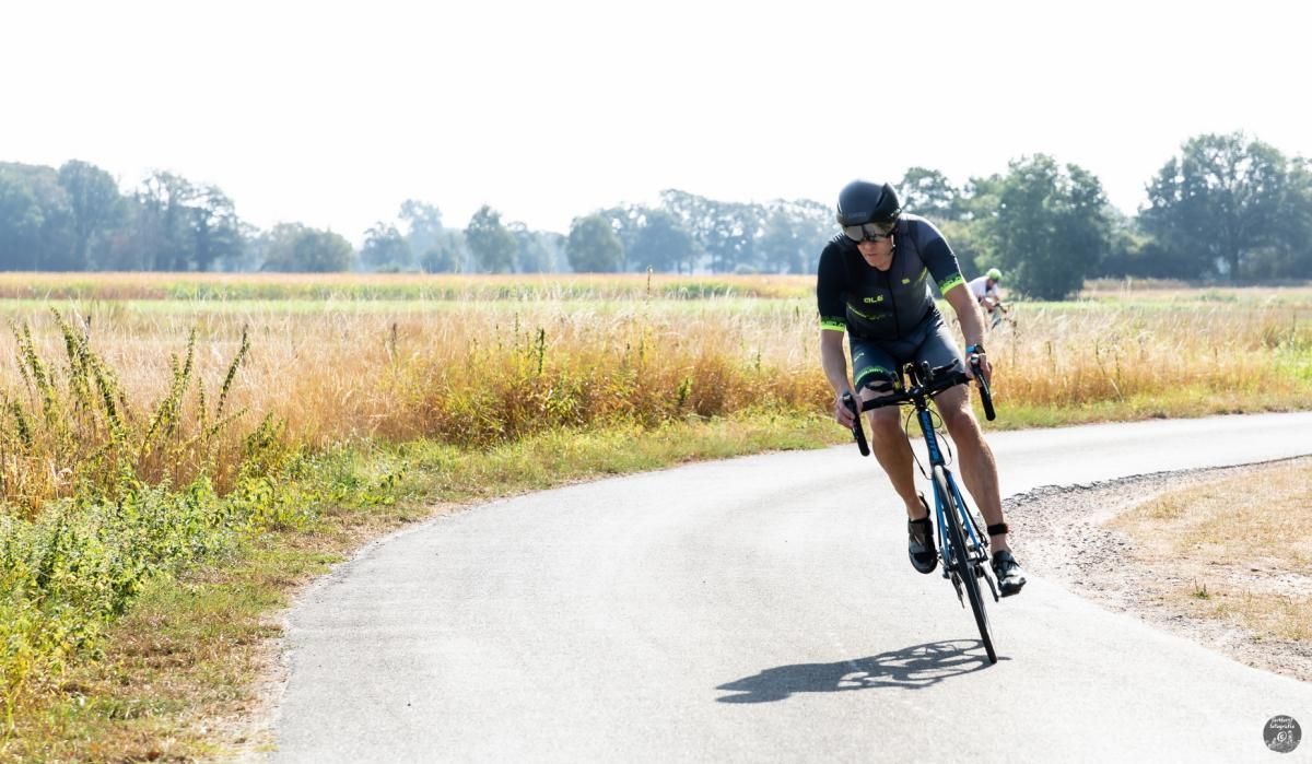 Een man fietst over een landweg.