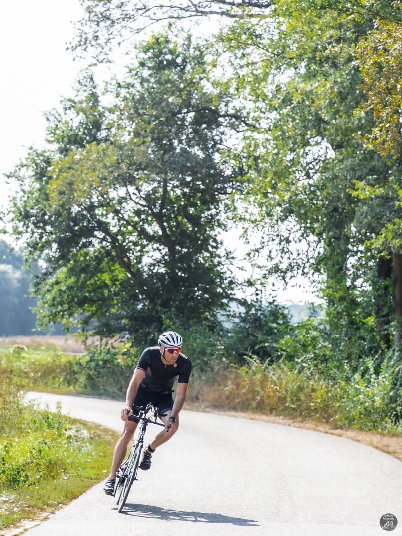 Een man fietst over een landweg.