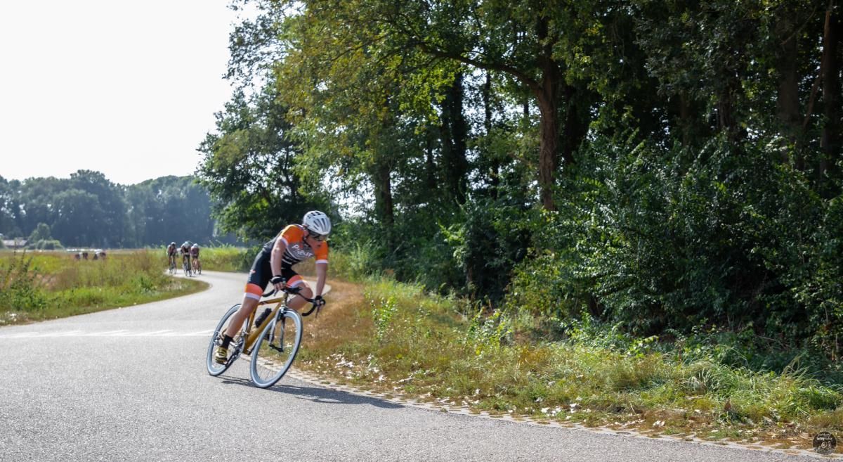 Een man fietst over een landweg.
