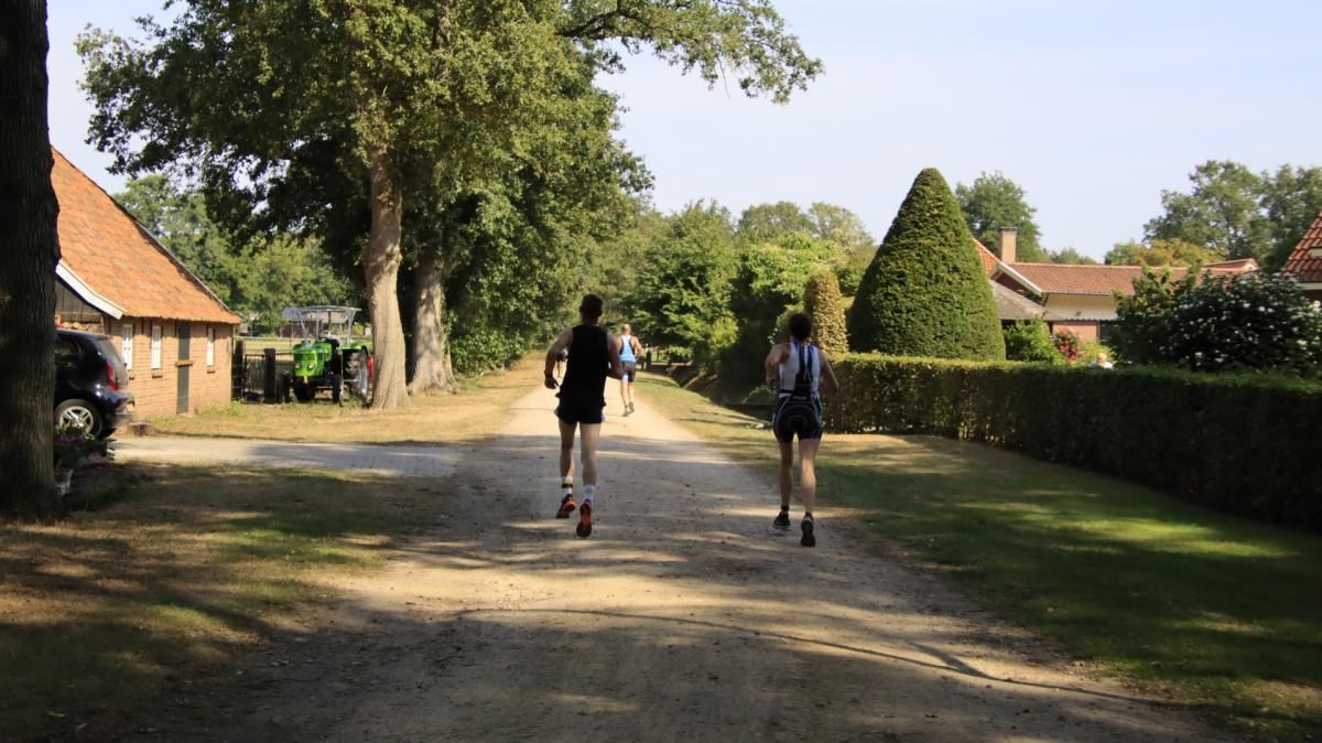 Twee mensen lopen over een onverharde weg.