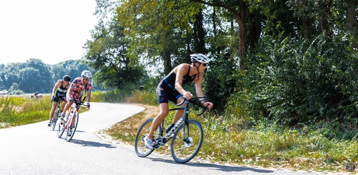 Een groep mensen fietst over een weg.
