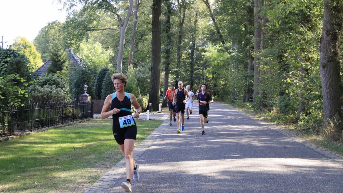 Een groep mensen rent over een weg.