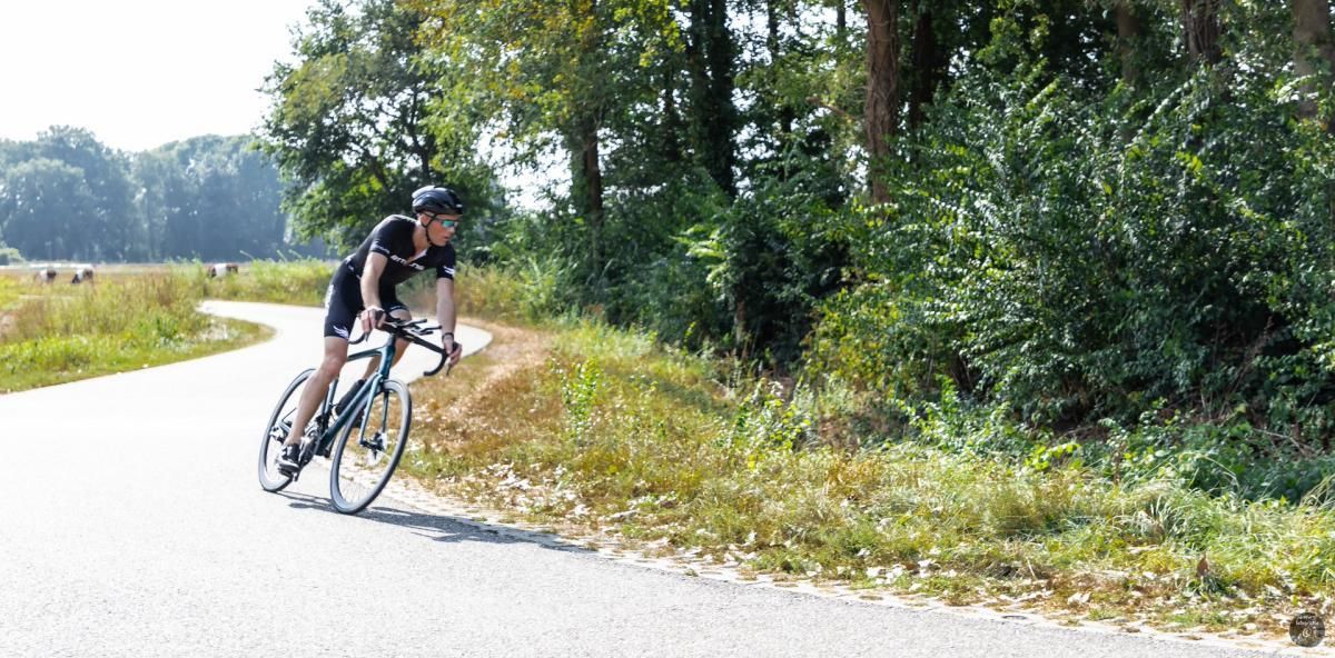 Een man fietst over een landweg.