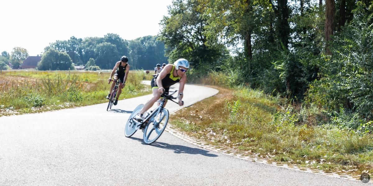 Twee mensen fietsen over een weg.