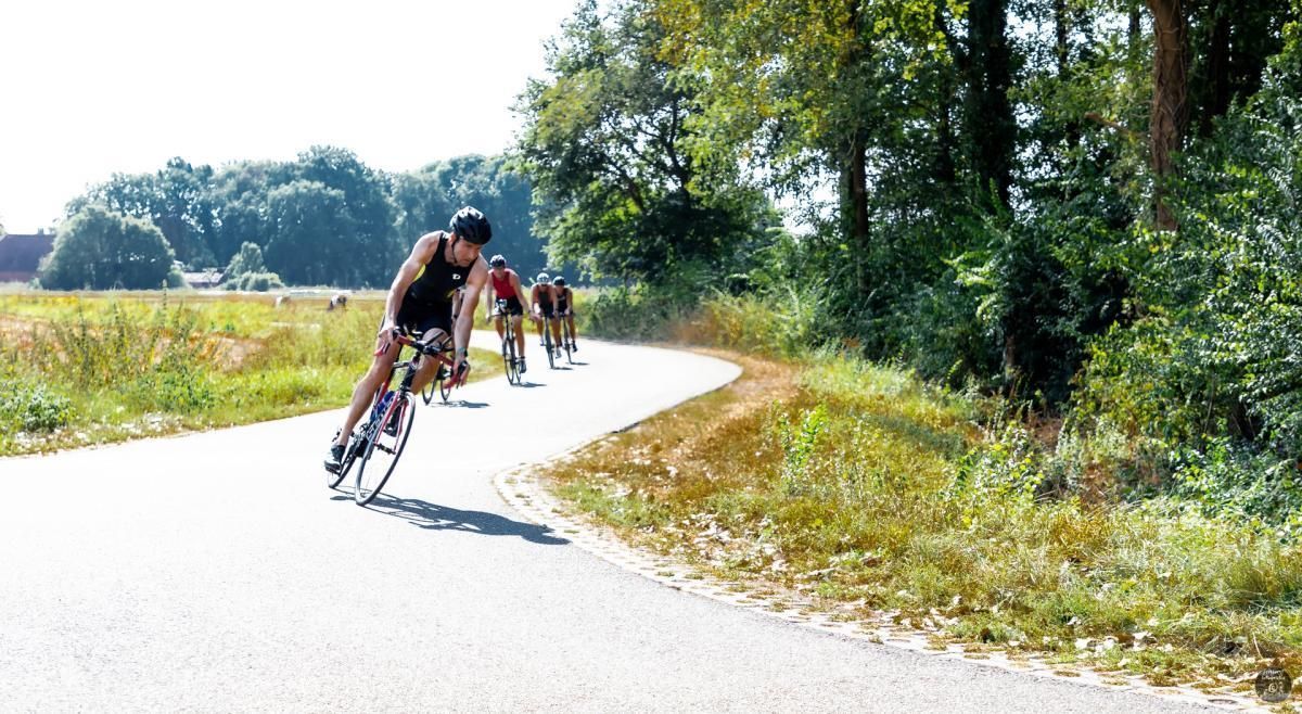 Een groep mensen fietst over een weg.
