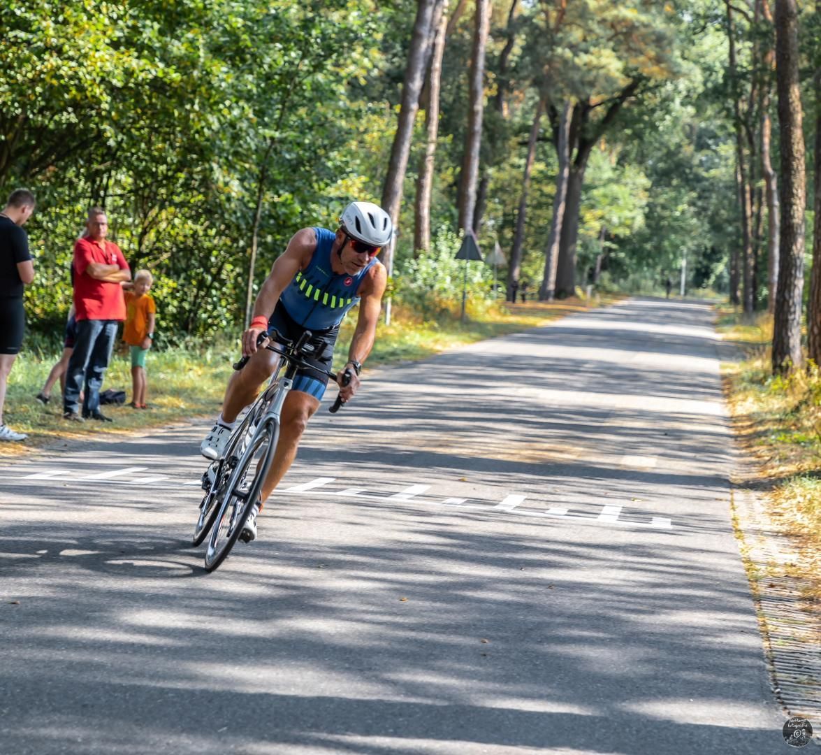 Een man fietst over een weg met een bord waarop 'a' staat