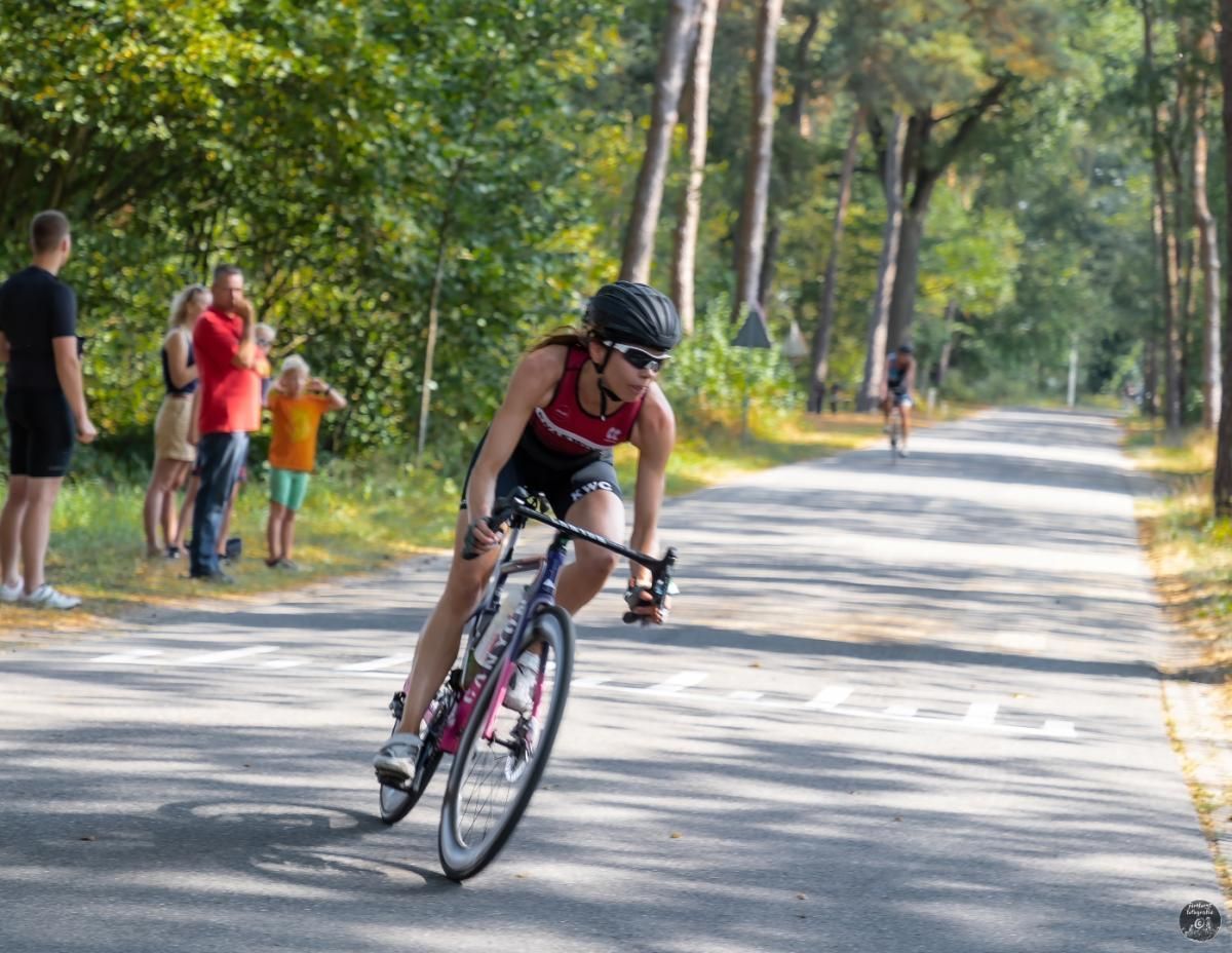 Een vrouw fietst over een weg.
