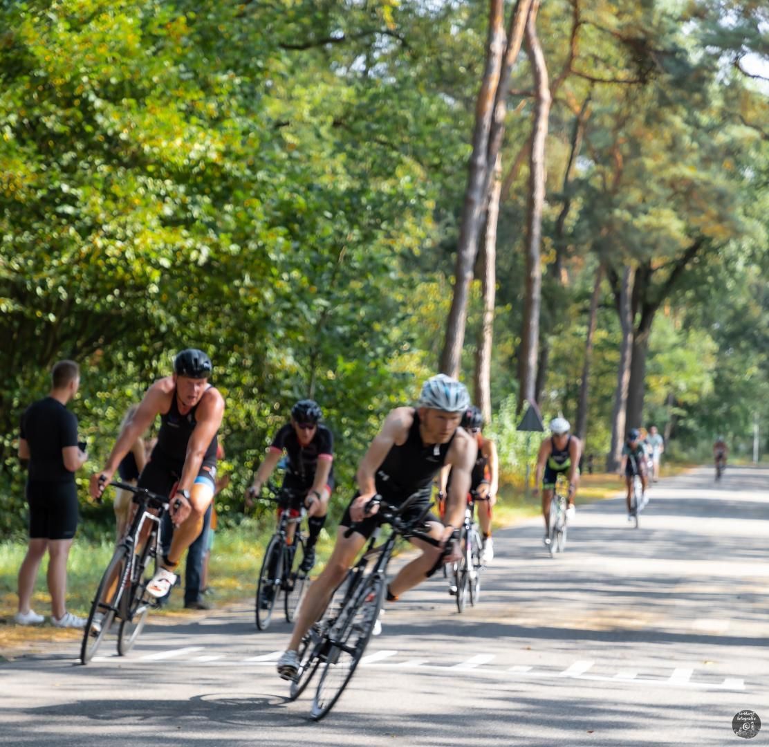 Een groep mensen fietst over een weg.