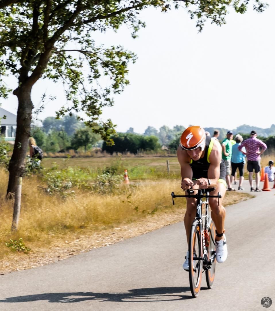 Een man die op een fiets rijdt met het nummer 7 op zijn helm
