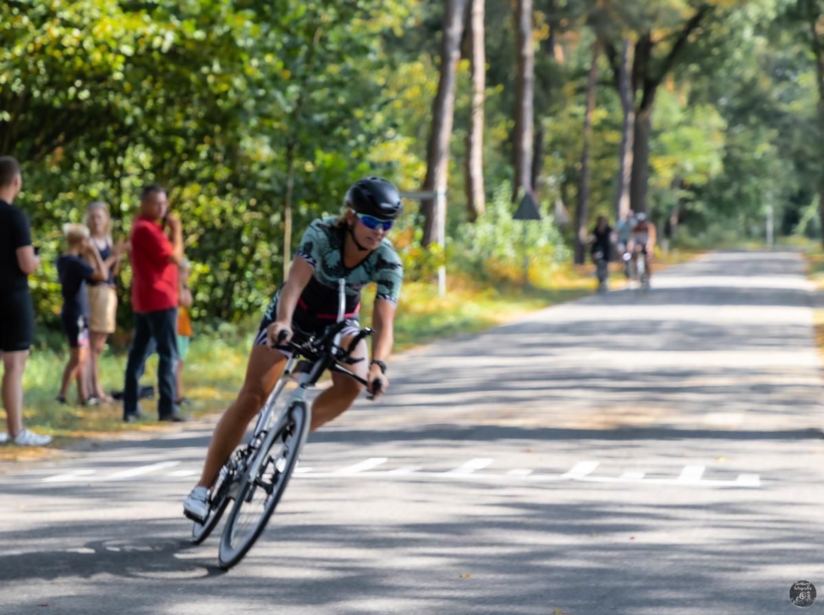 Een vrouw fietst over een weg.