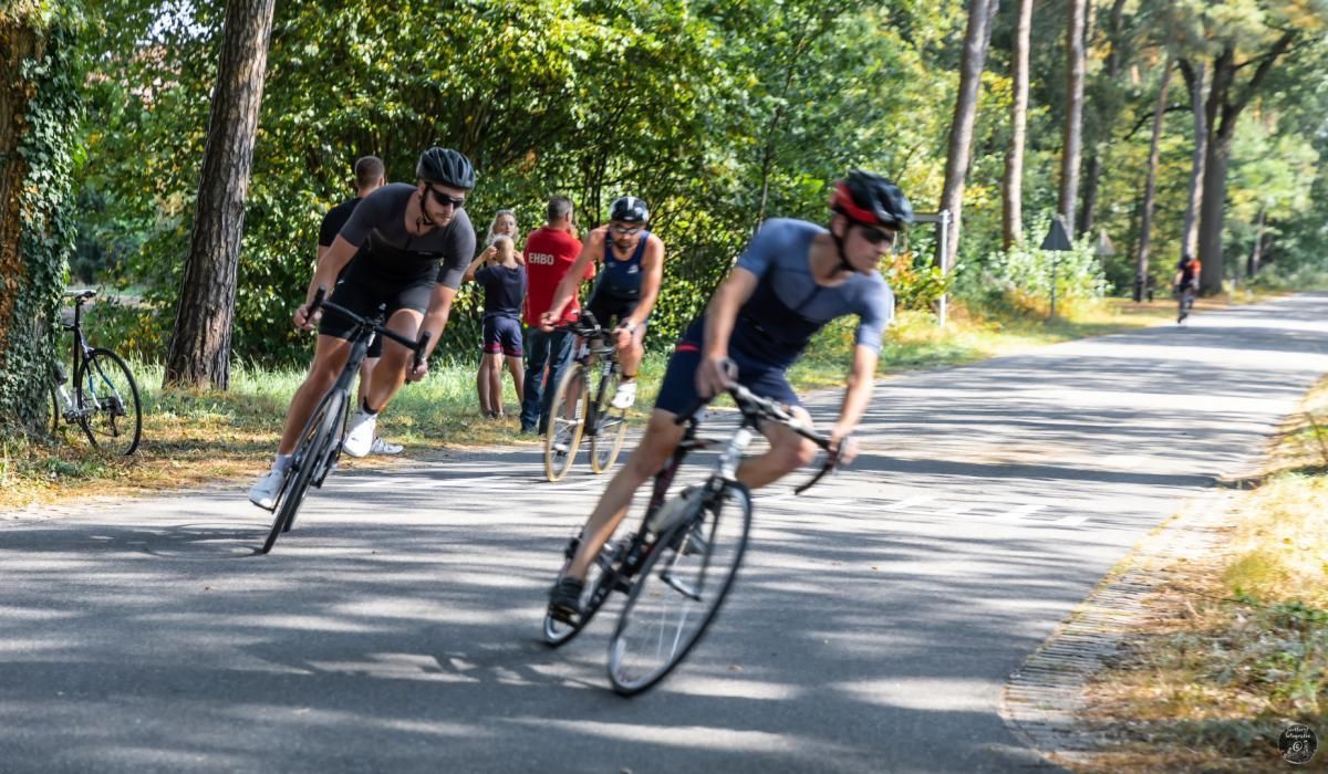 Een groep mensen fietst over een weg.