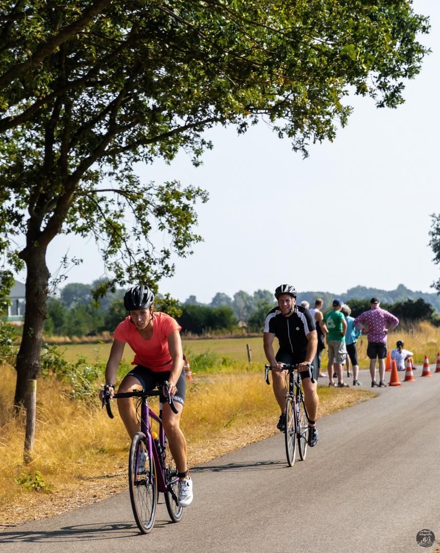 Een groep mensen fietst over een weg