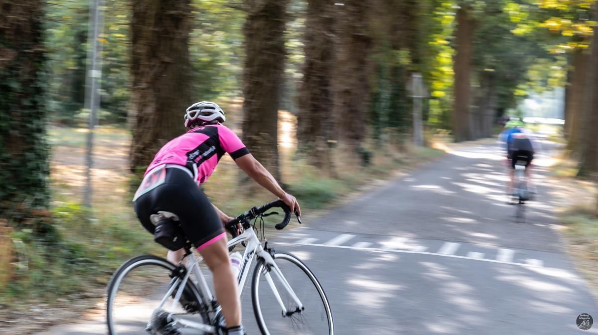 Een vrouw fietst over een weg.