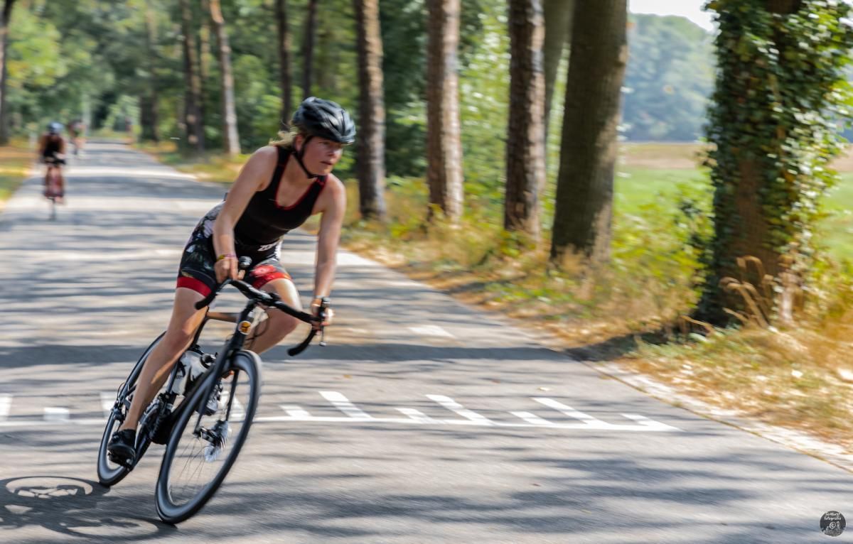 Een vrouw fietst over een weg.
