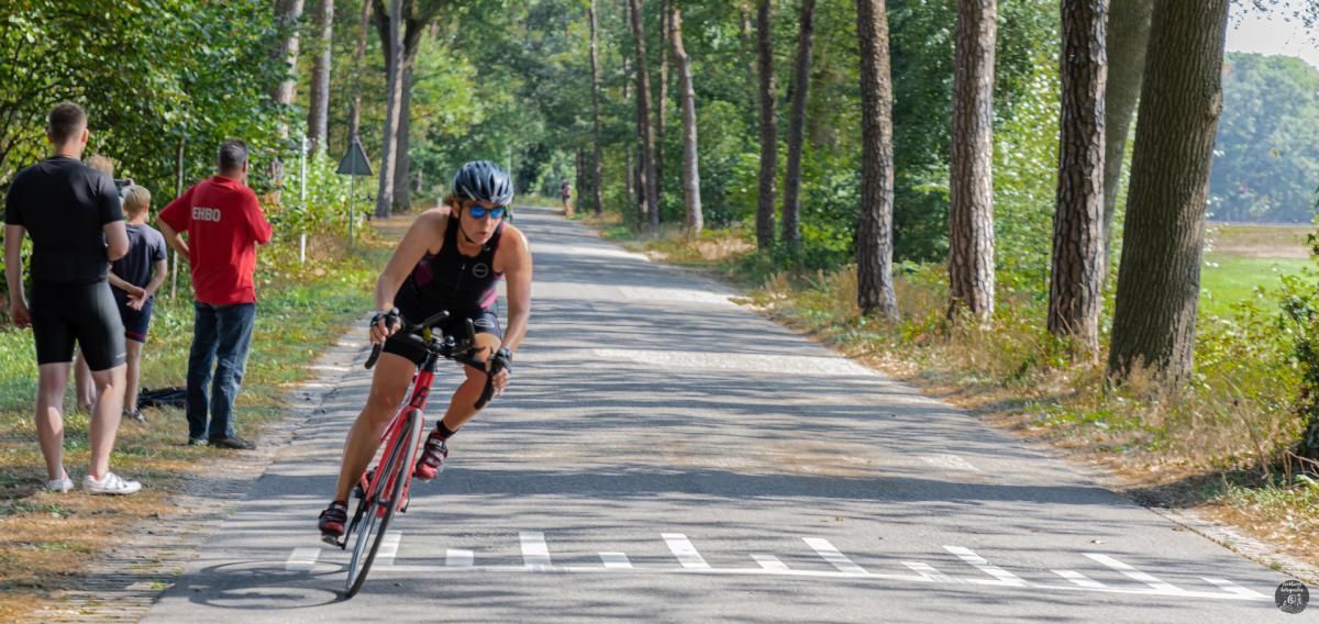Een vrouw fietst over een weg.