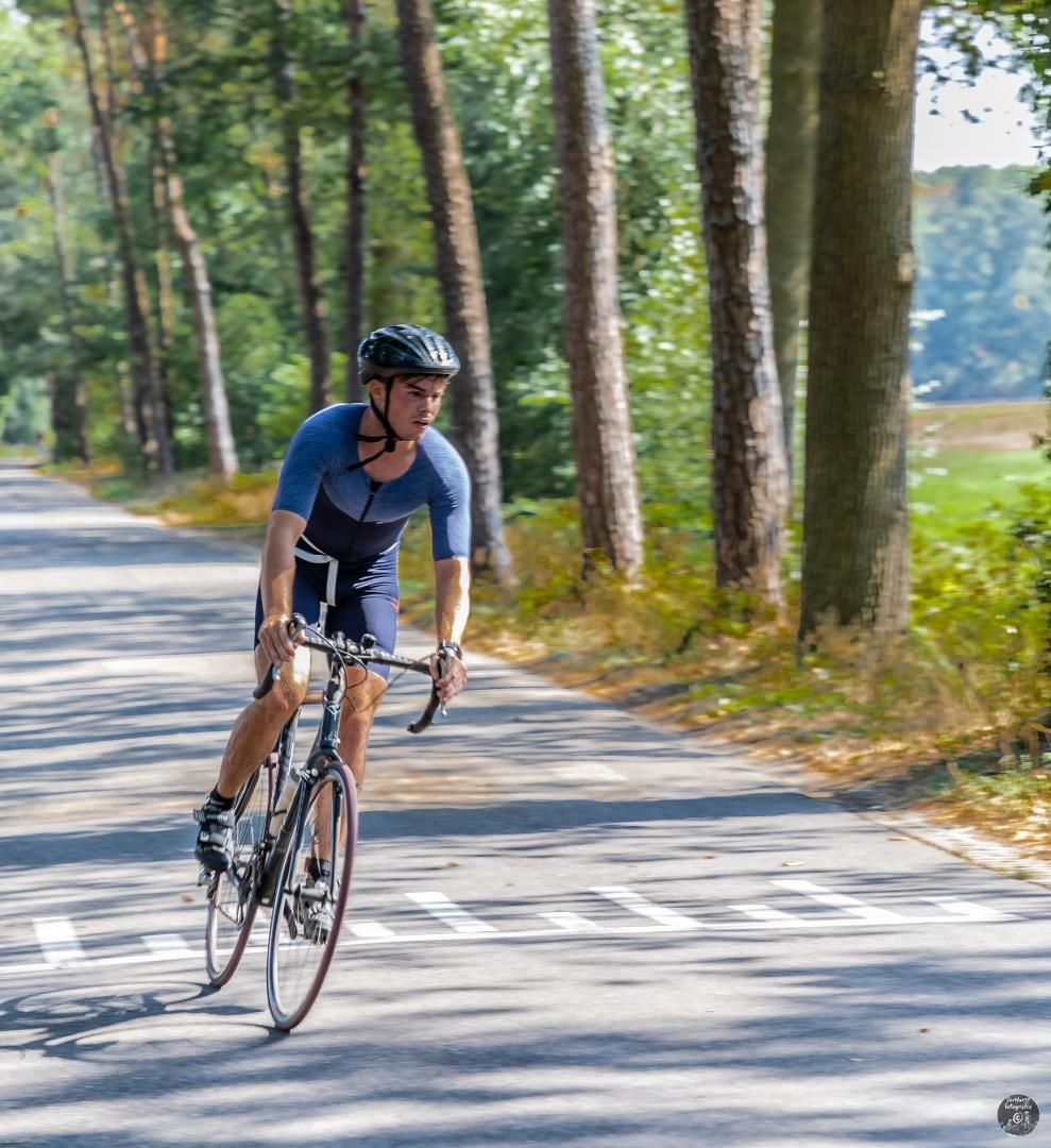 Een man fietst over een weg.