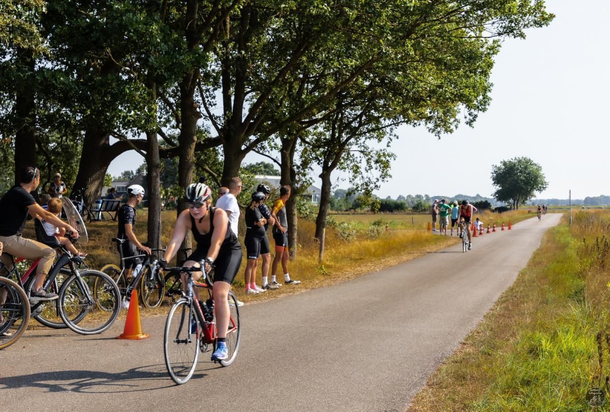 Een groep mensen fietst over een weg.