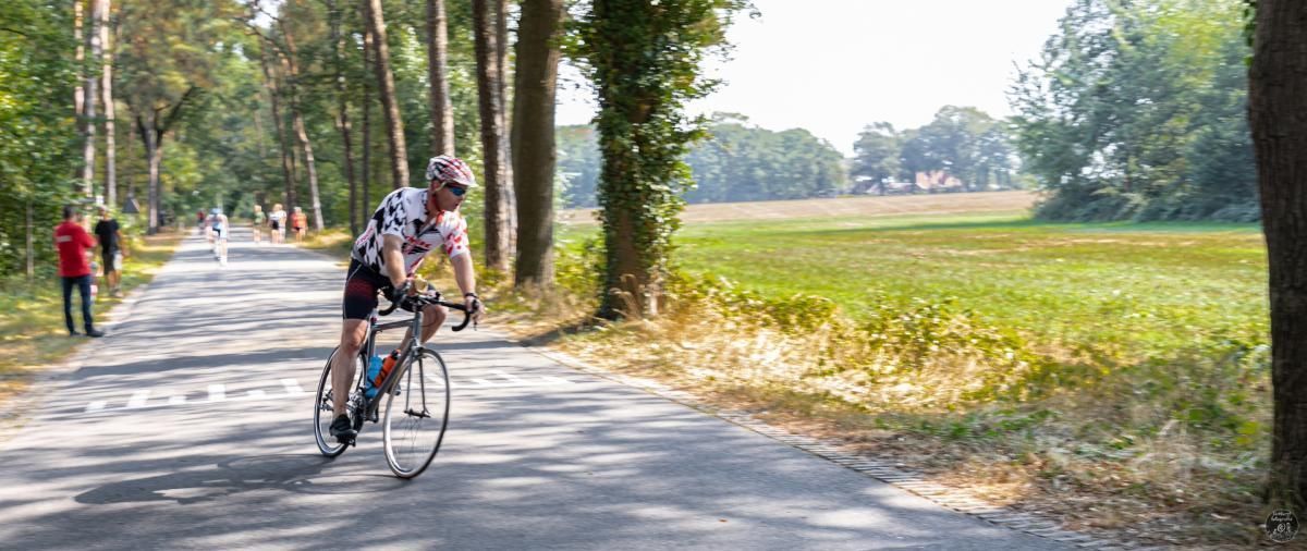 Een man fietst over een landweg.