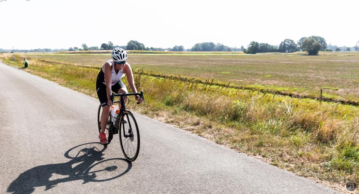 Een vrouw fietst over een landweg.