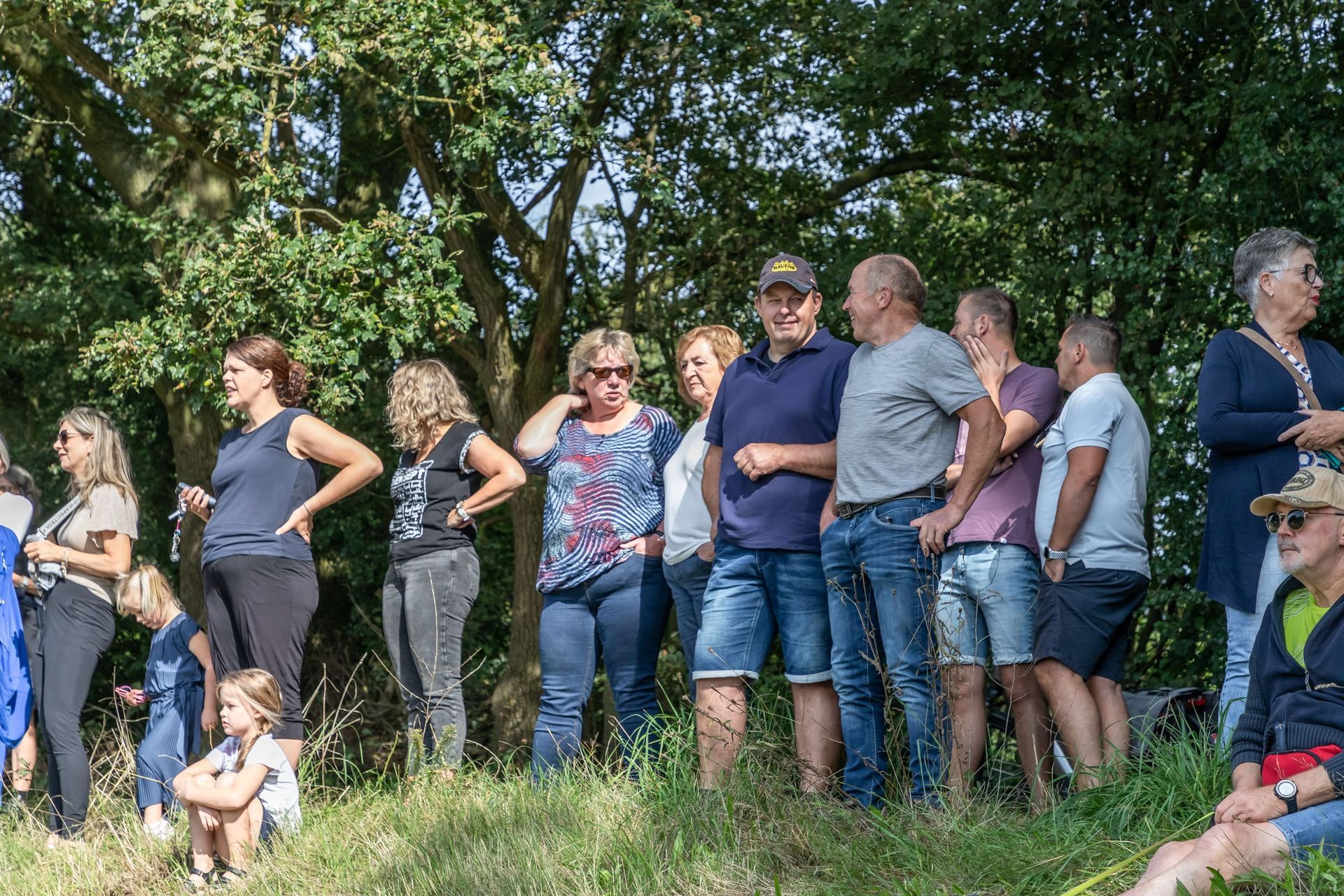 Een groep mensen staat in een grasveld.