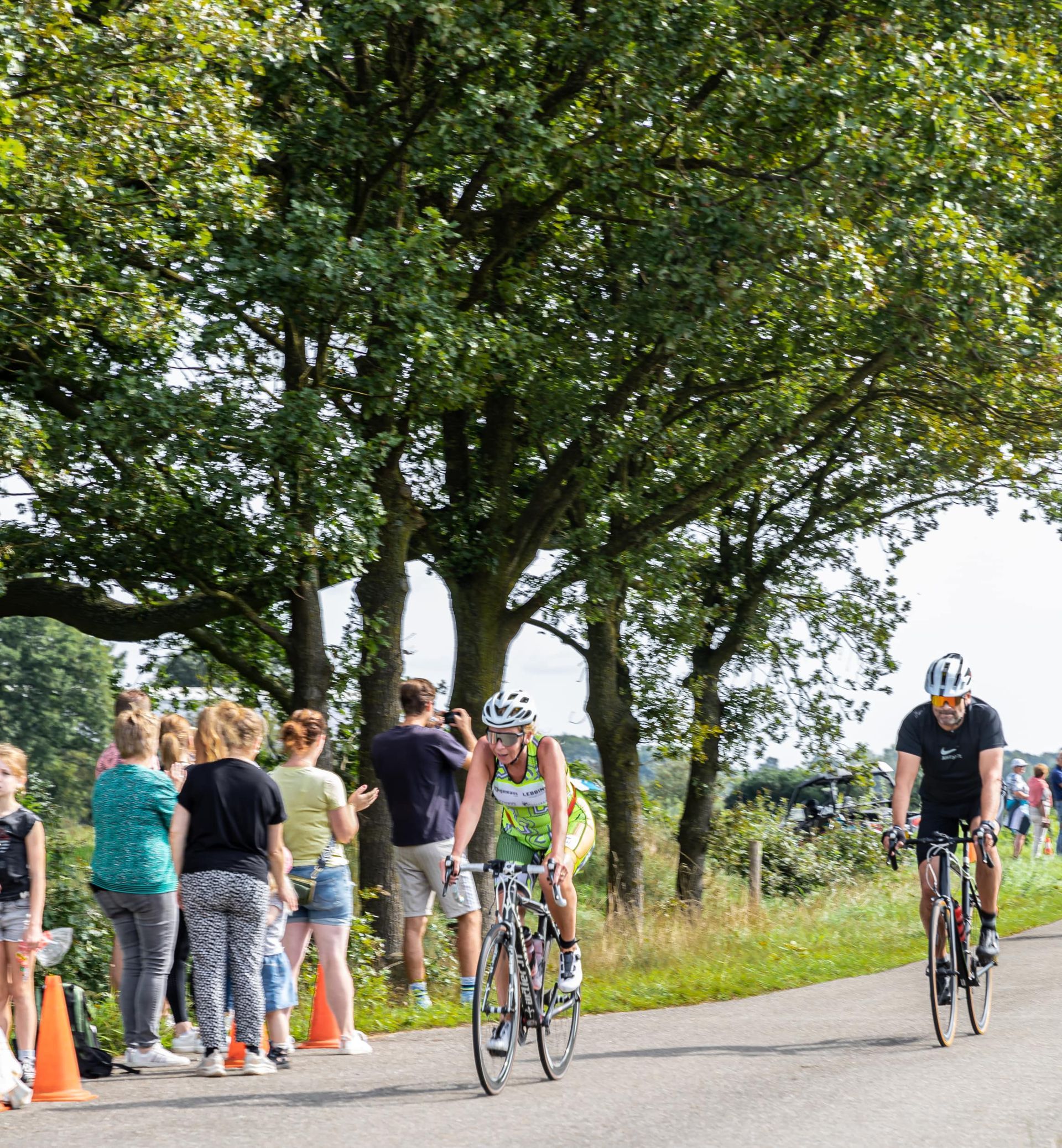 Een groep mensen fietst over een weg.
