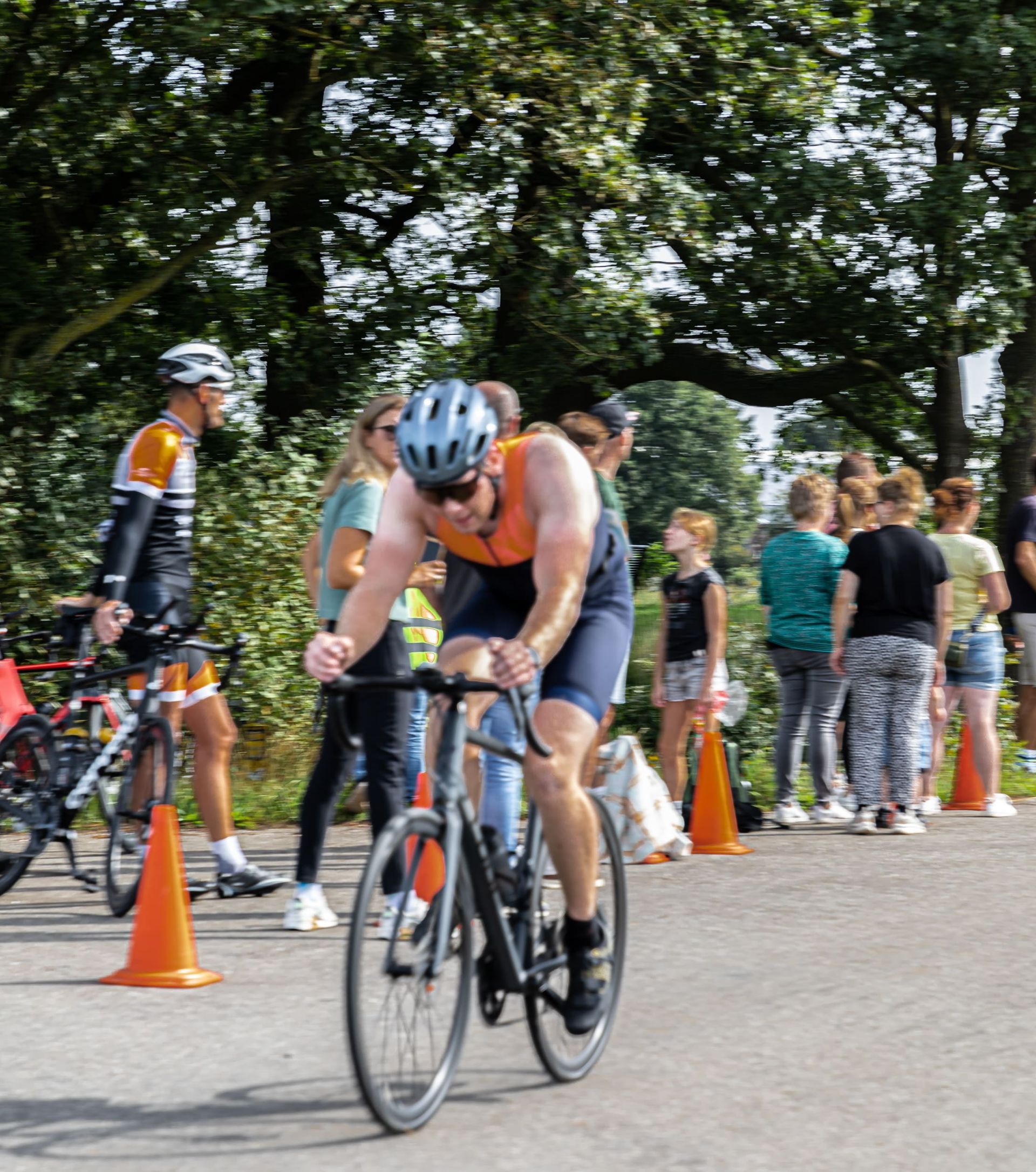 Een man met een helm rijdt op een fiets over een weg