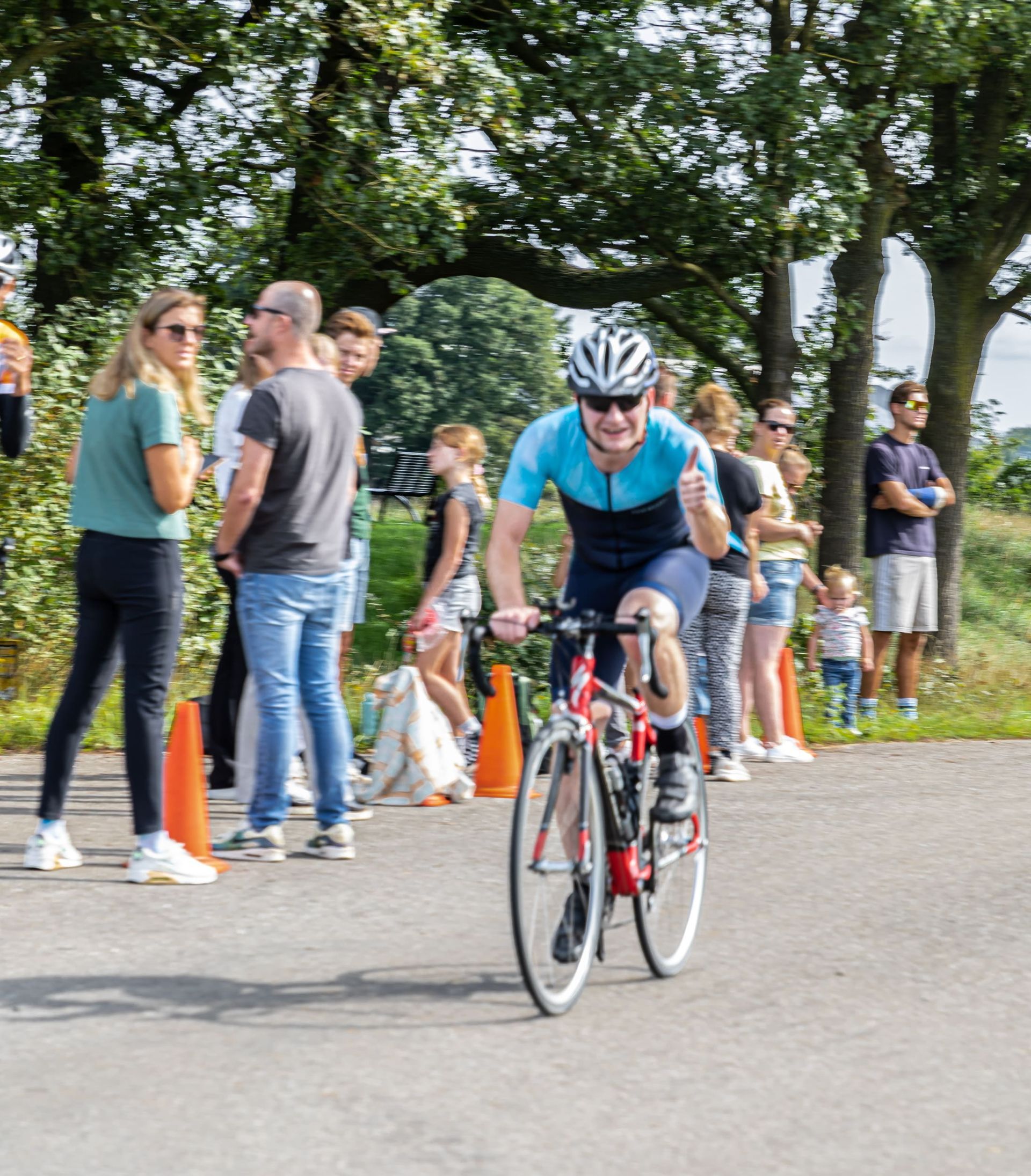 Een man met een helm rijdt op een fiets over een weg