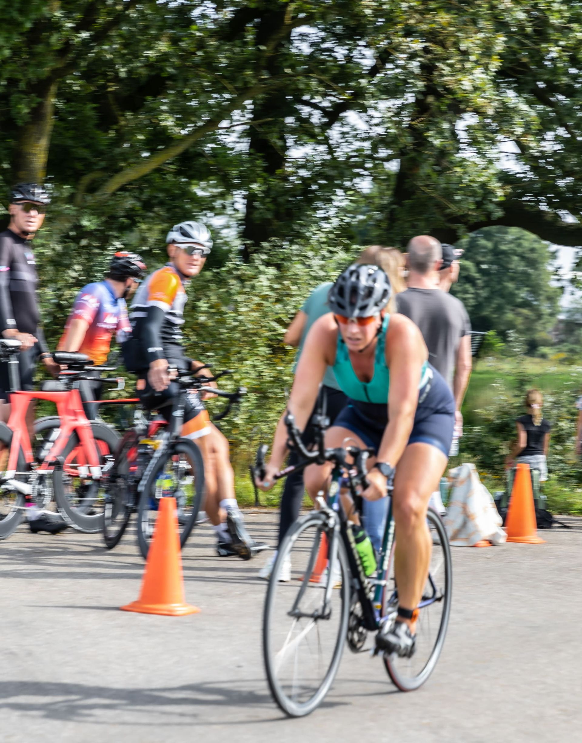 Een vrouw fietst met andere fietsers over een weg