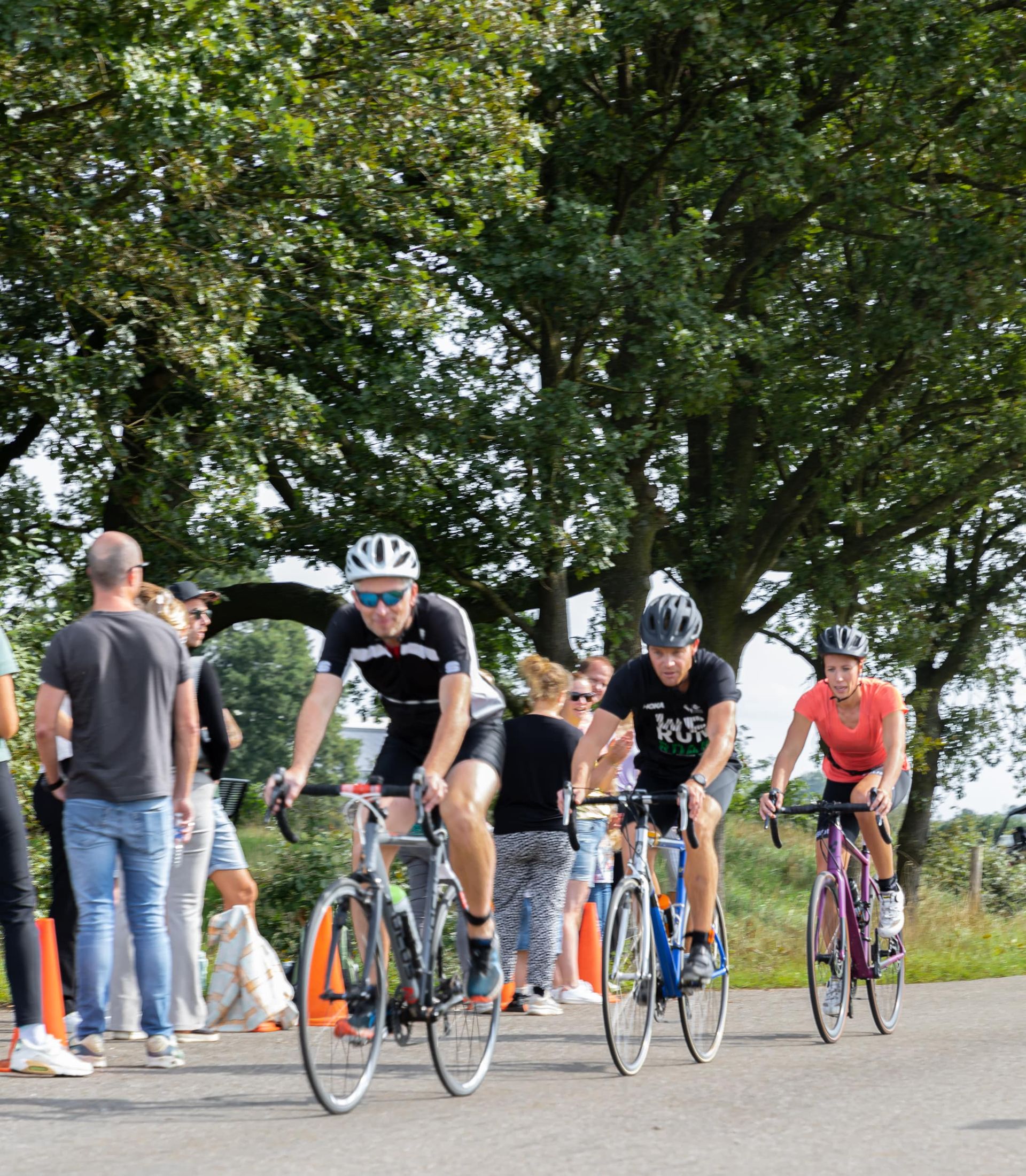 Een groep mensen fietst over een weg.
