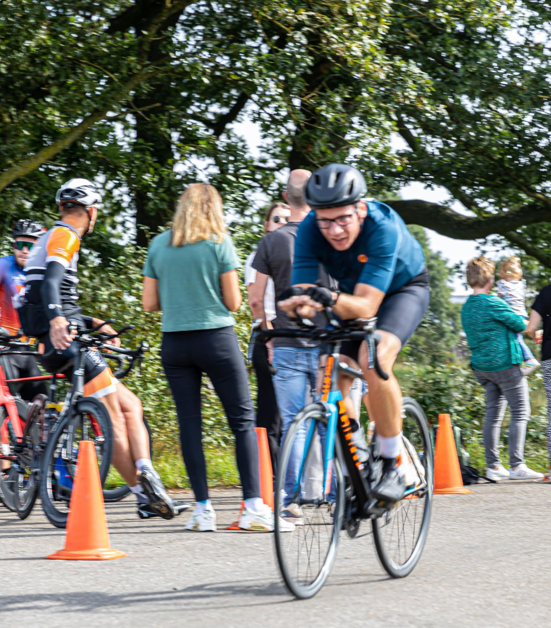 Een man met een helm rijdt op een fiets over een weg