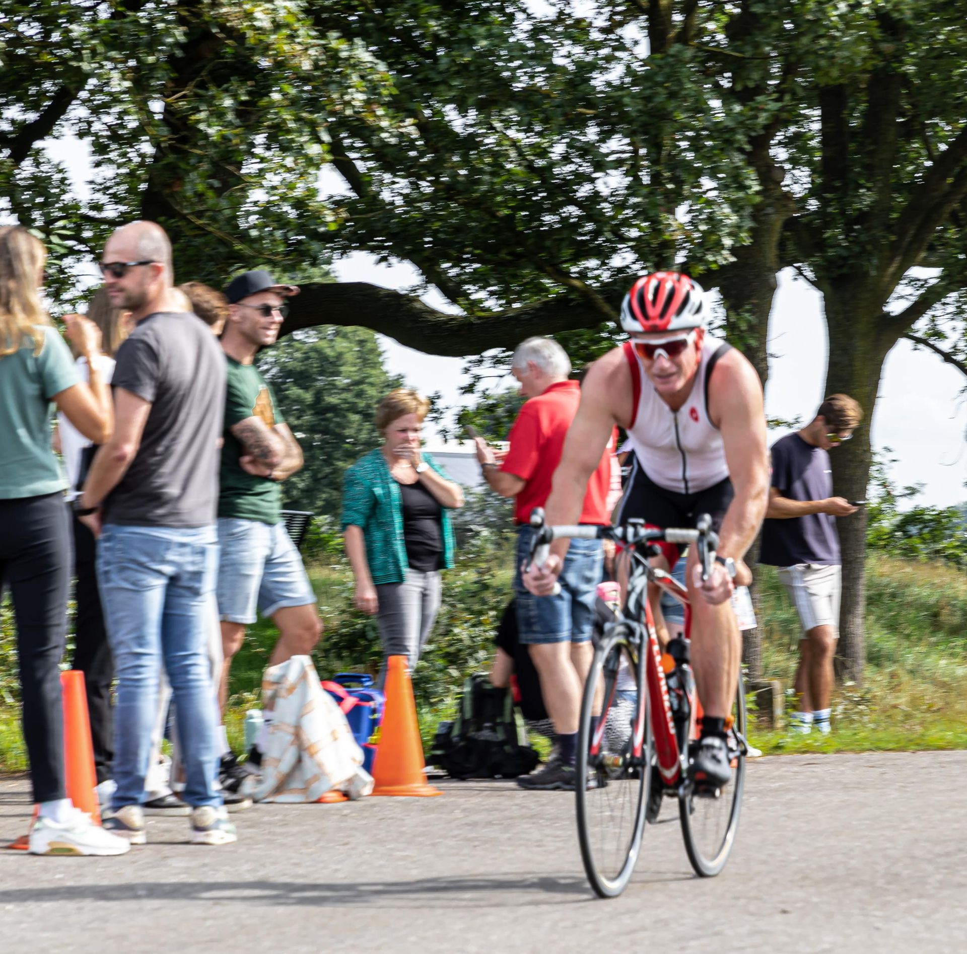 Een man met een rode helm rijdt op een fiets