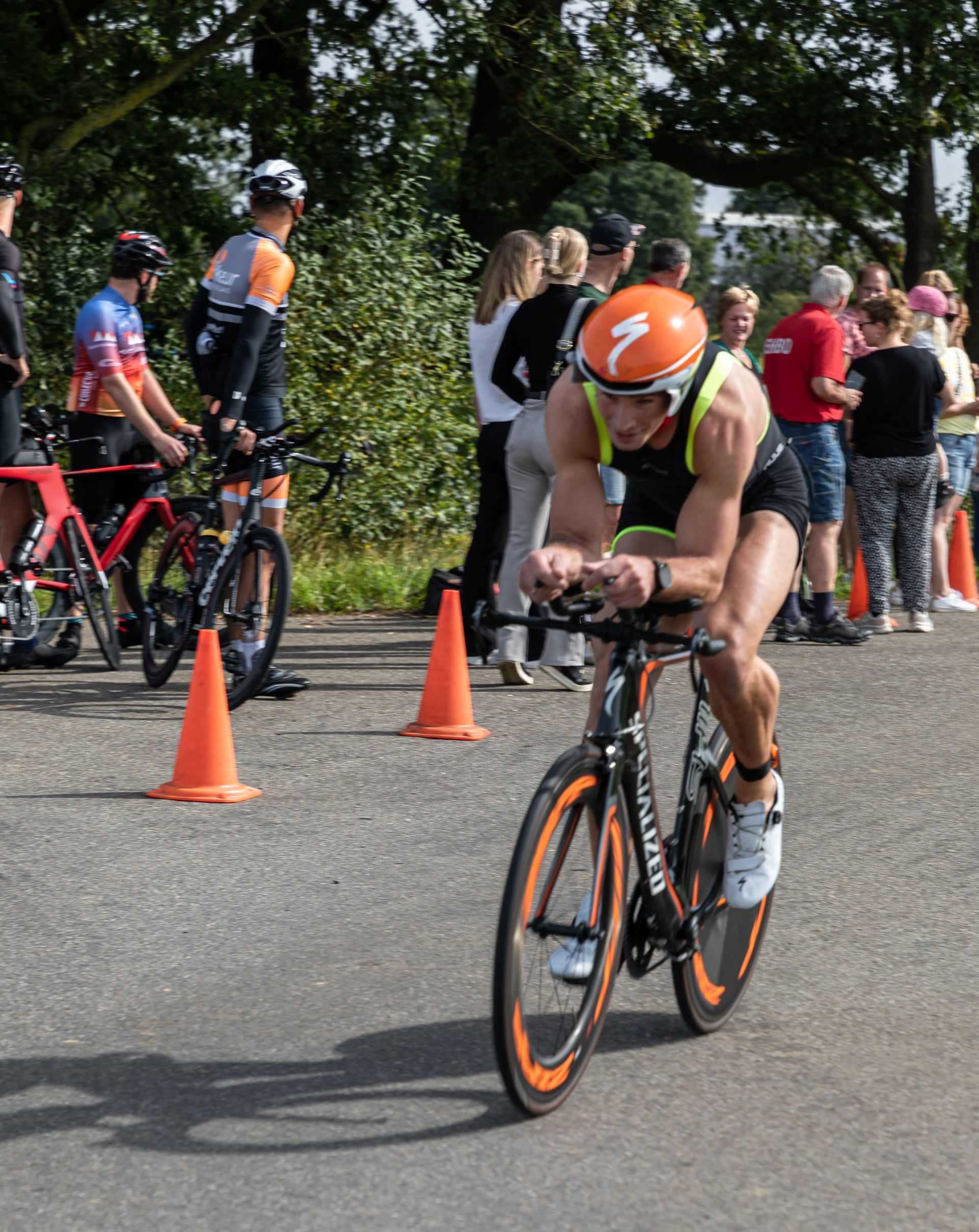 Een man met een speciale helm rijdt op een fiets