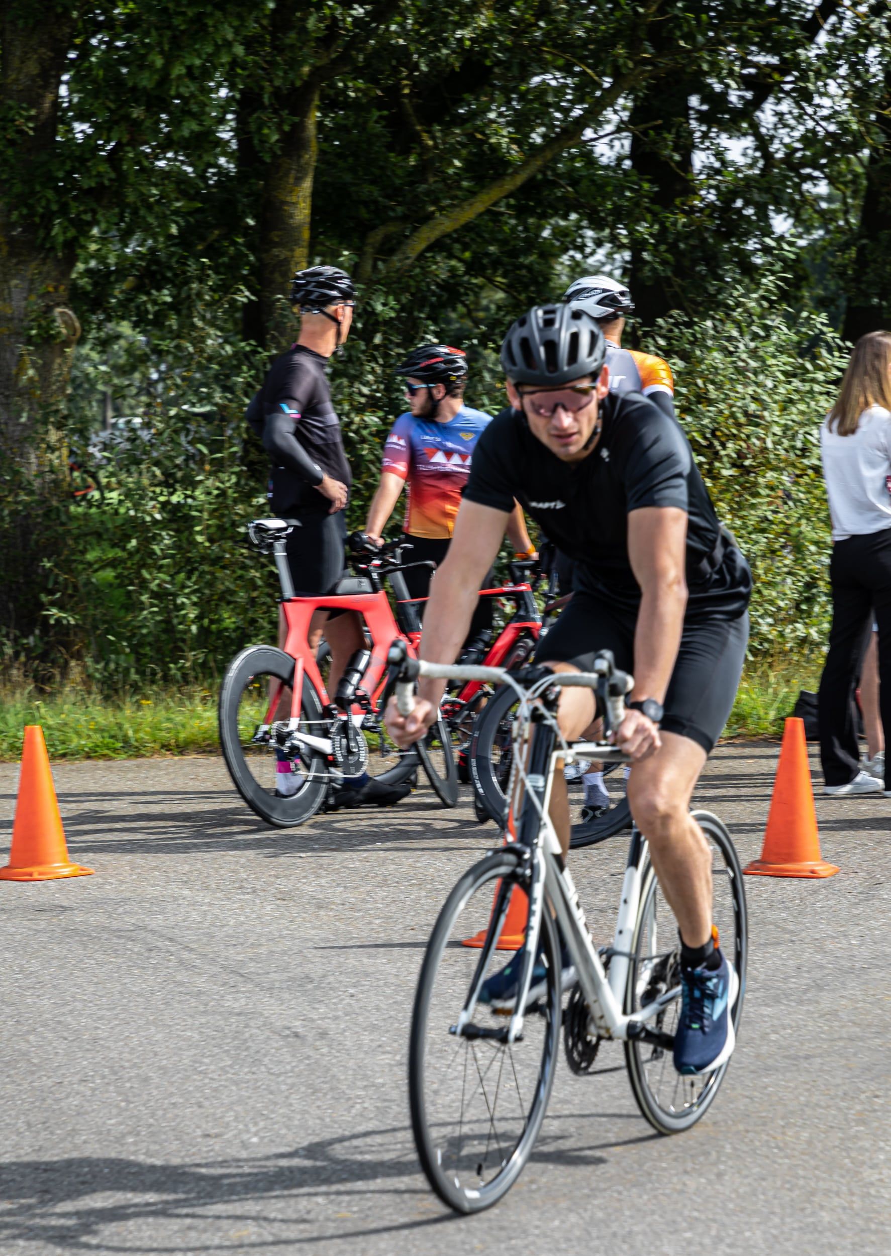 Een man met een helm rijdt op een fiets op een weg