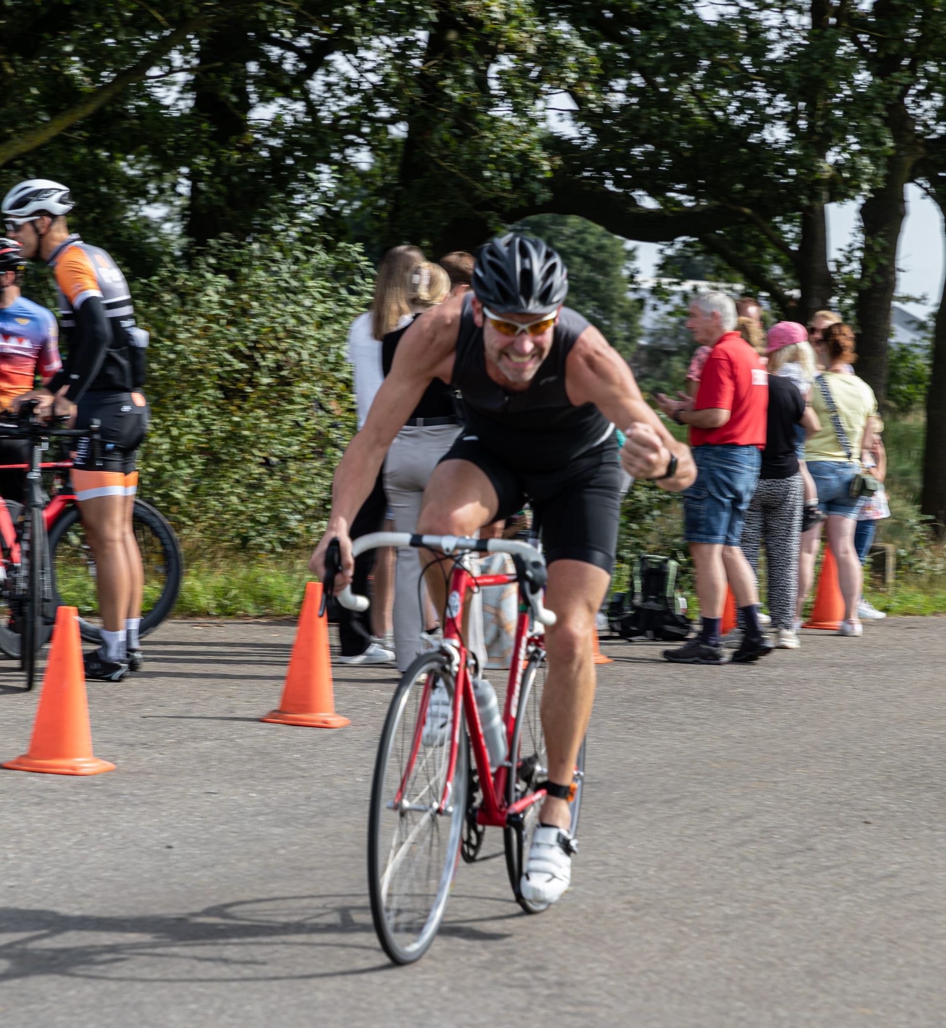 Een man met een helm rijdt op een fiets over een weg