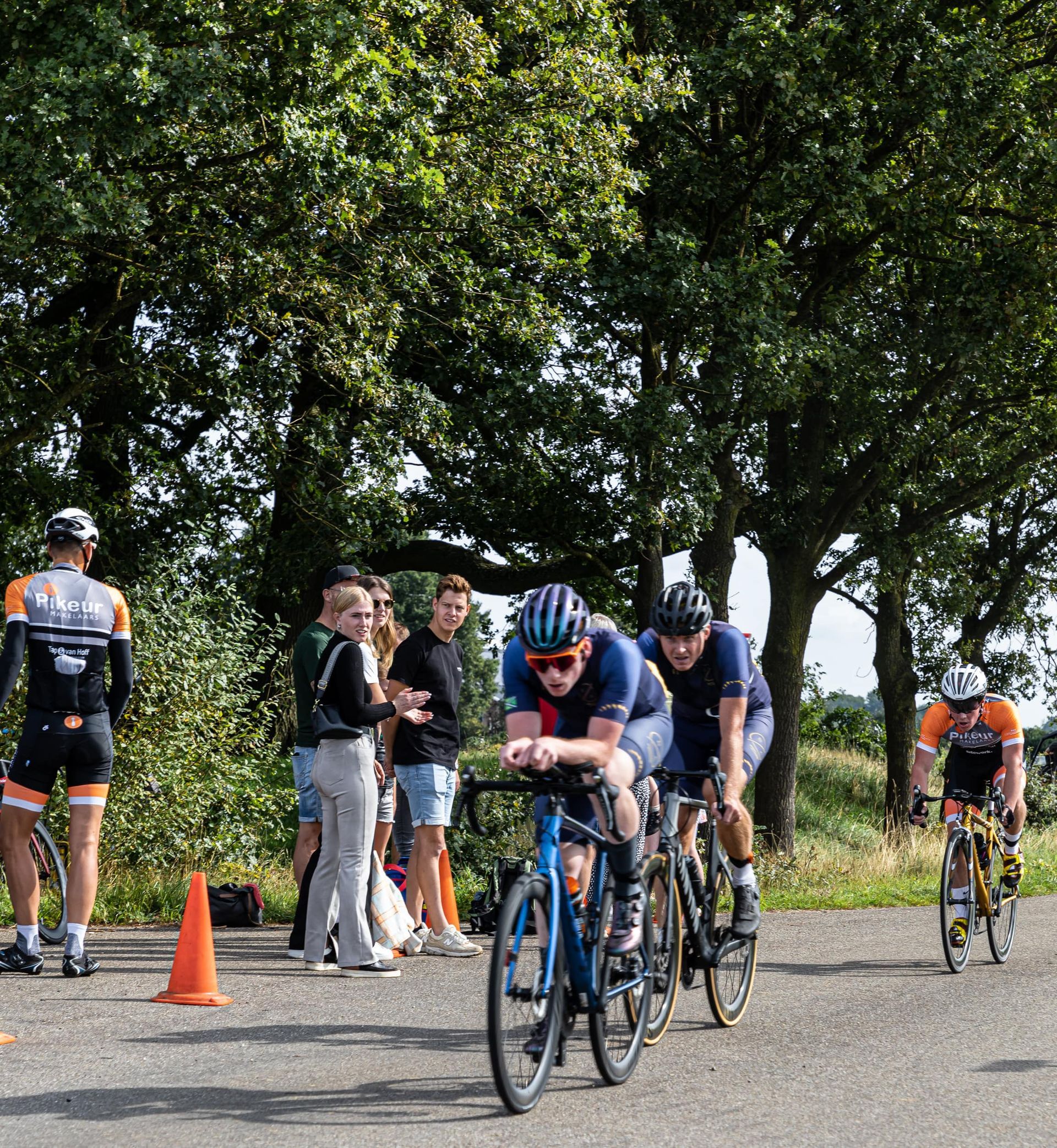 Een groep mensen fietst over een weg.