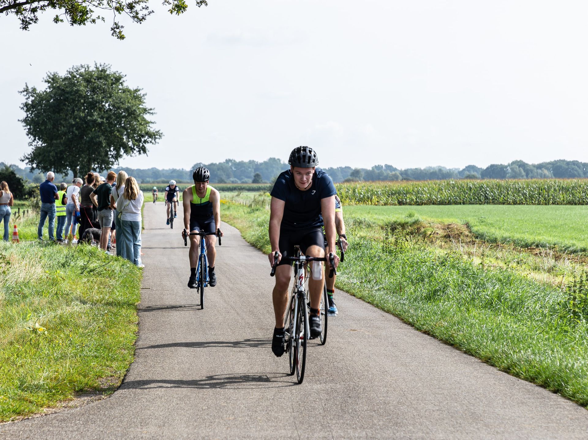 Een groep mensen fietst over een weg.