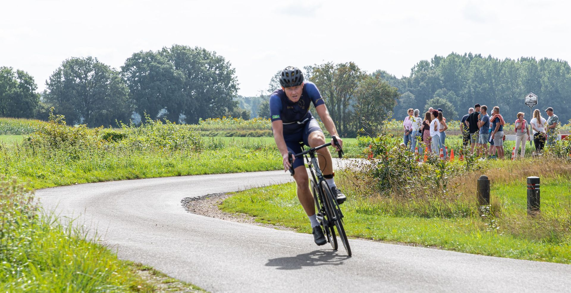 Een man fietst op een bochtige weg.