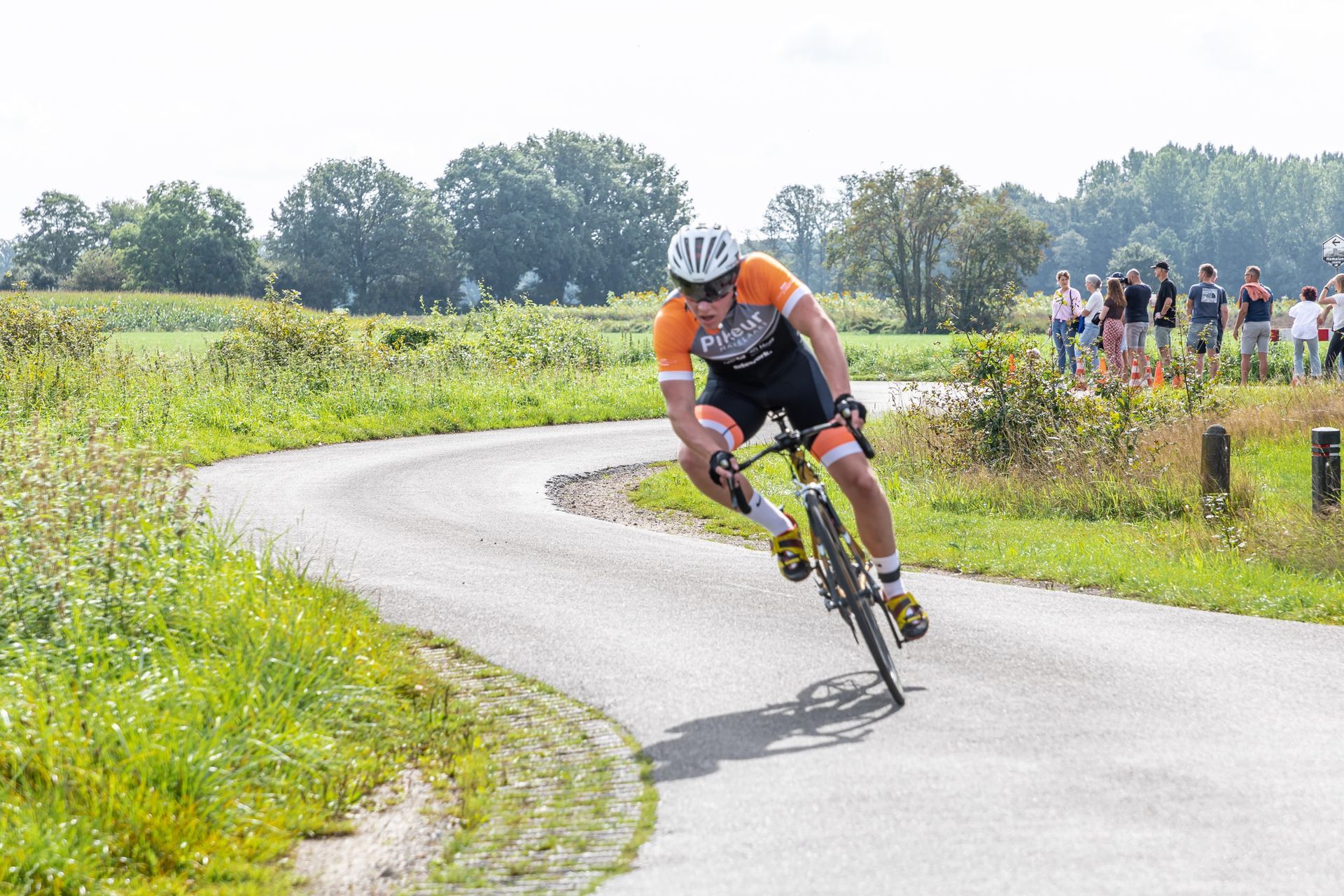 Een man fietst over een bochtige weg.