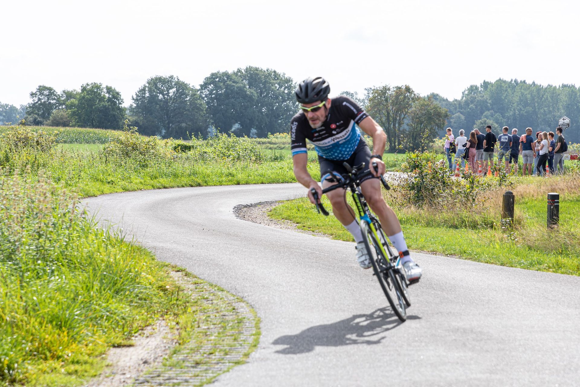 Een man fietst over een bochtige weg.