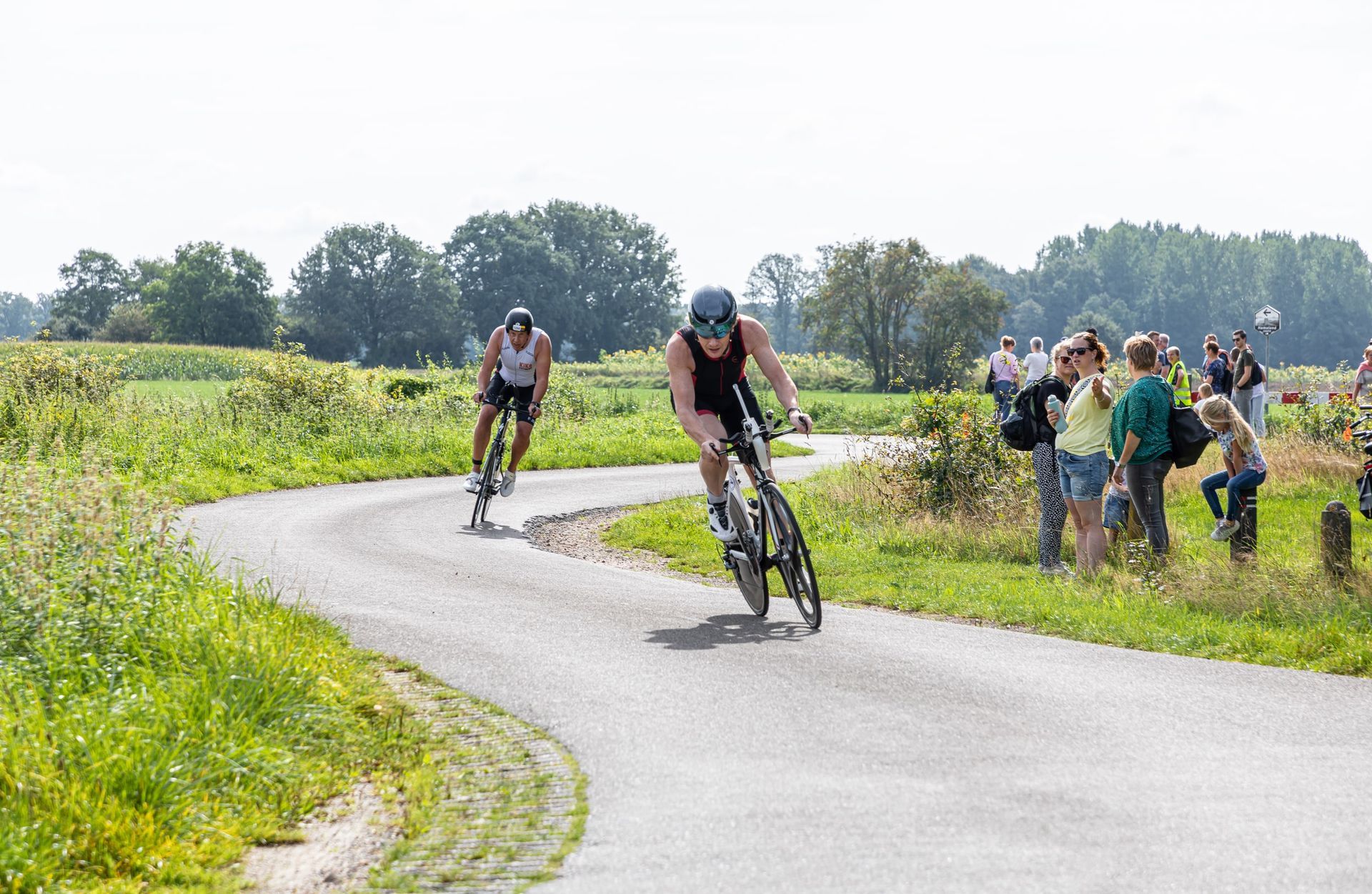 Een groep mensen fietst over een weg.