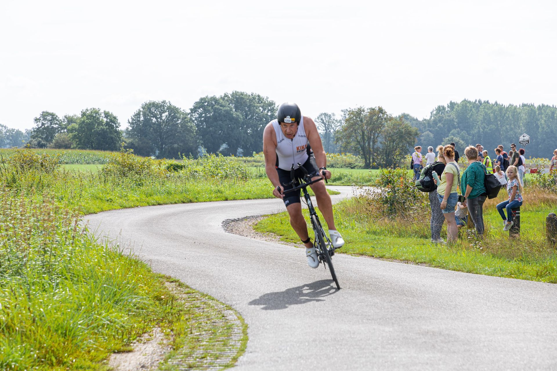 Een man fietst over een bochtige weg.