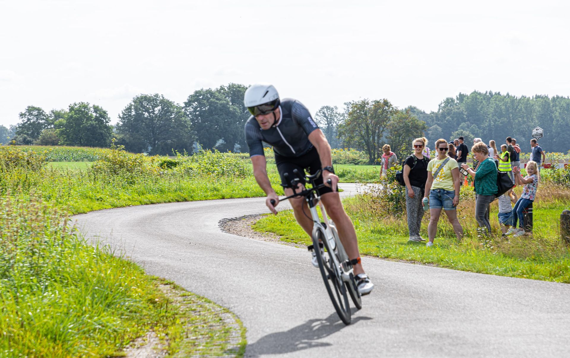 Een man fietst over een bochtige weg.