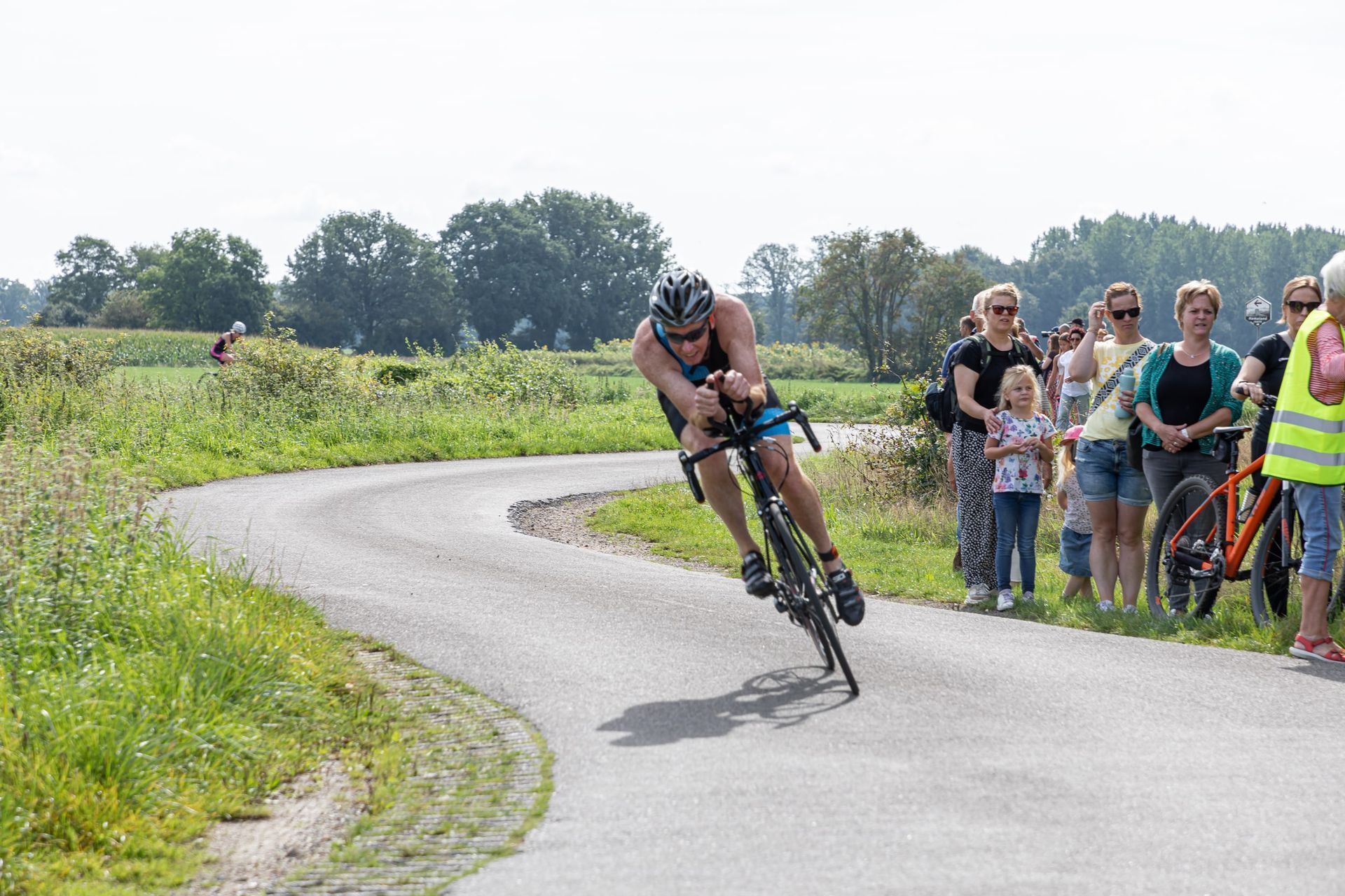 Een man fietst over een bochtige weg.