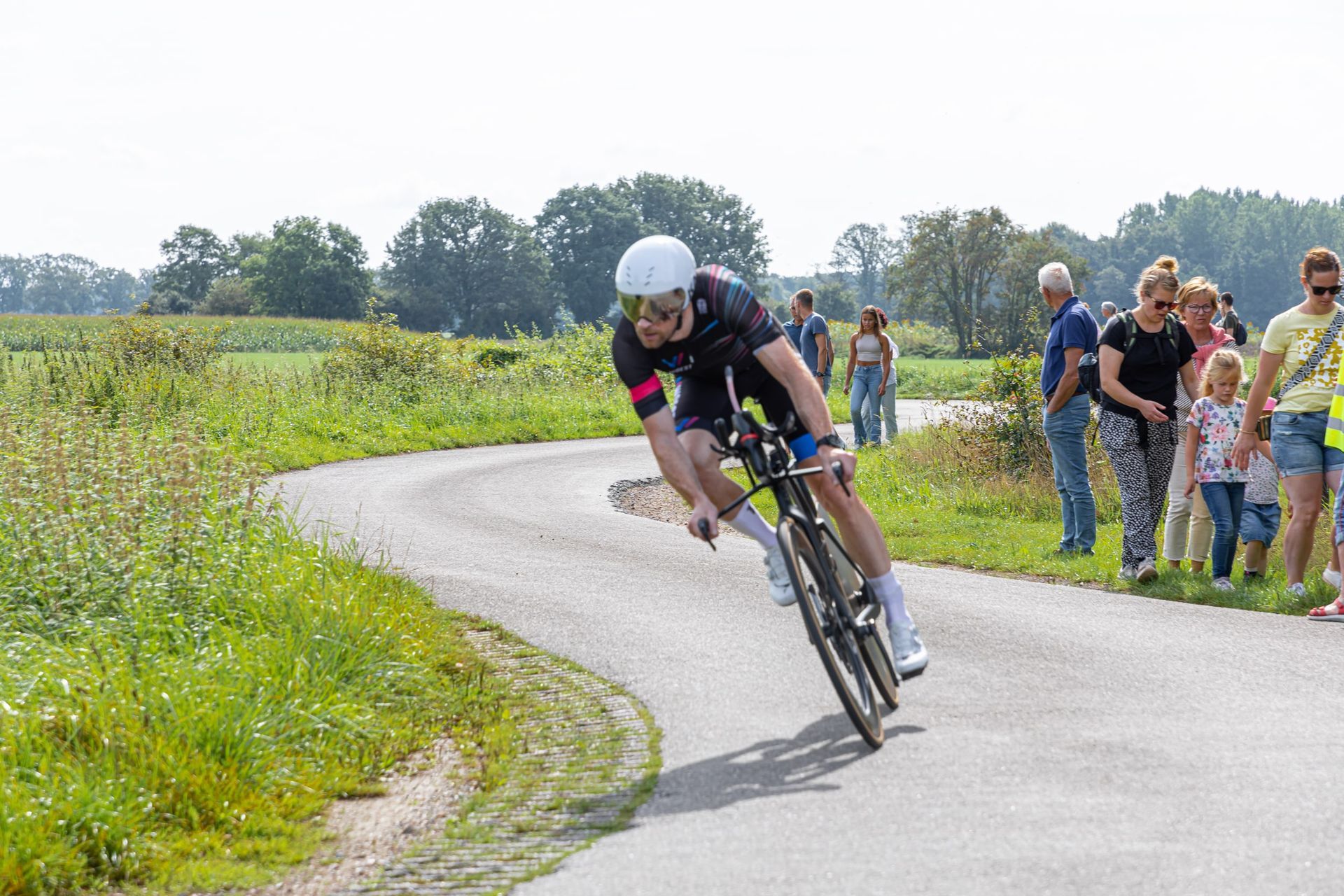 Een man fietst over een bochtige weg.