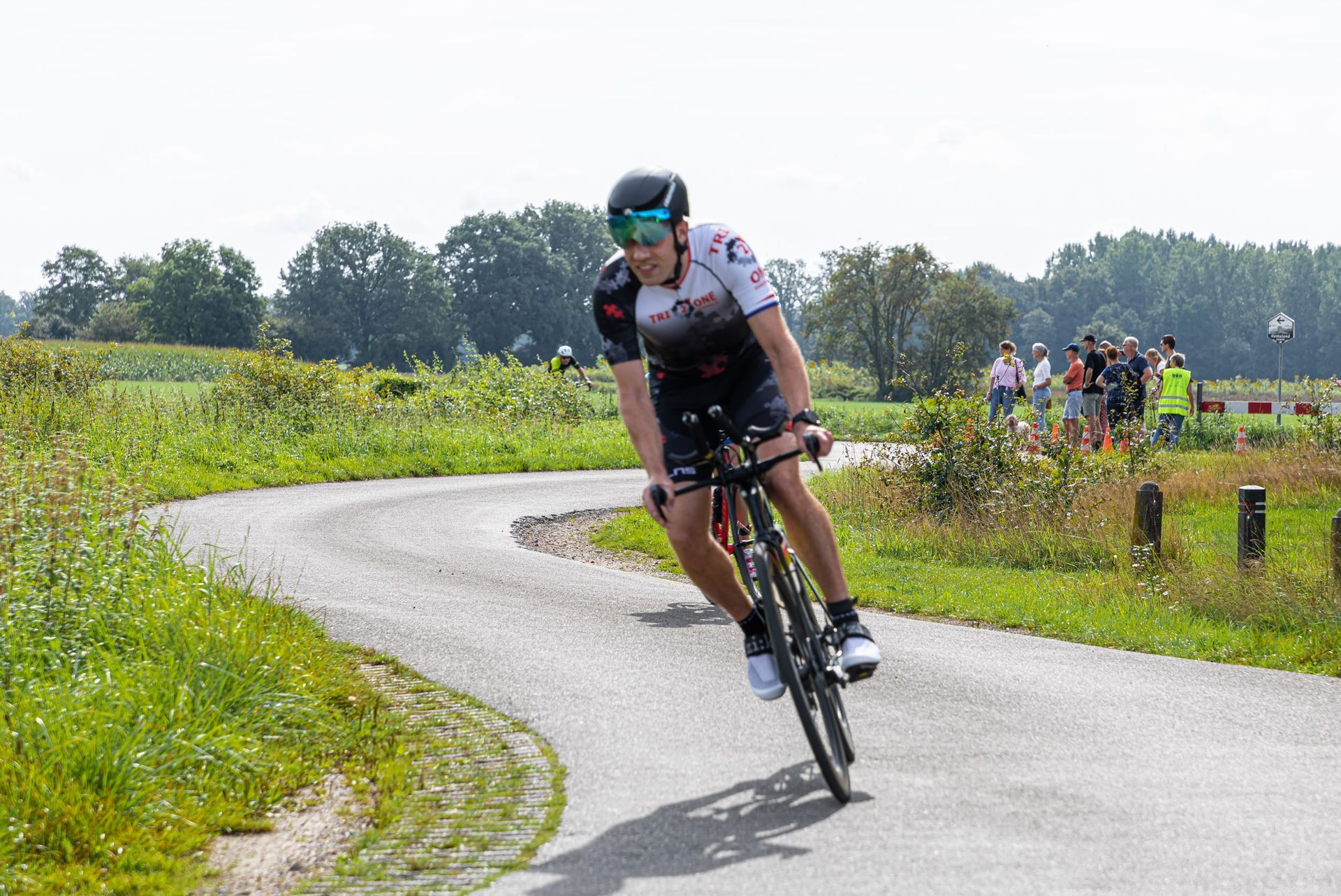 Een man fietst over een bochtige weg.