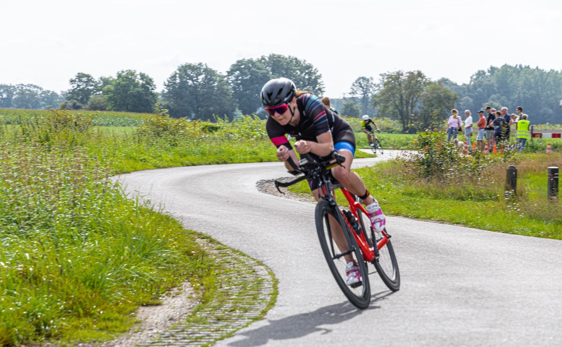 Een vrouw fietst over een bochtige weg.