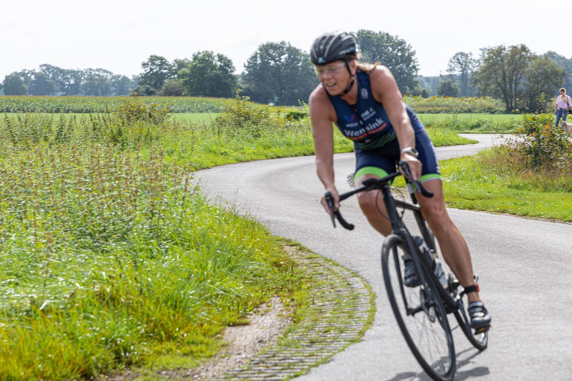 Een vrouw fietst over een weg.
