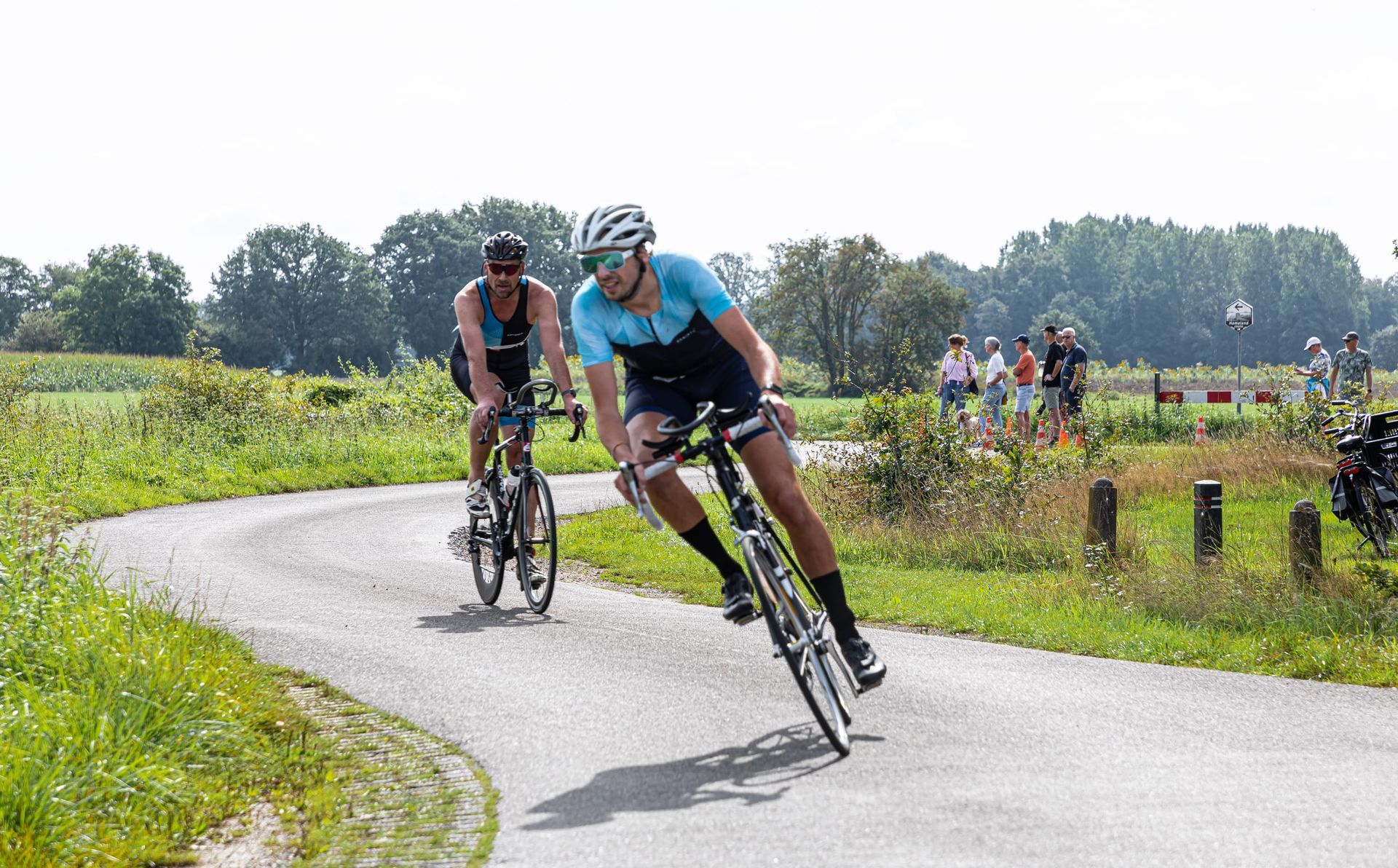 Twee mannen fietsen over een weg.