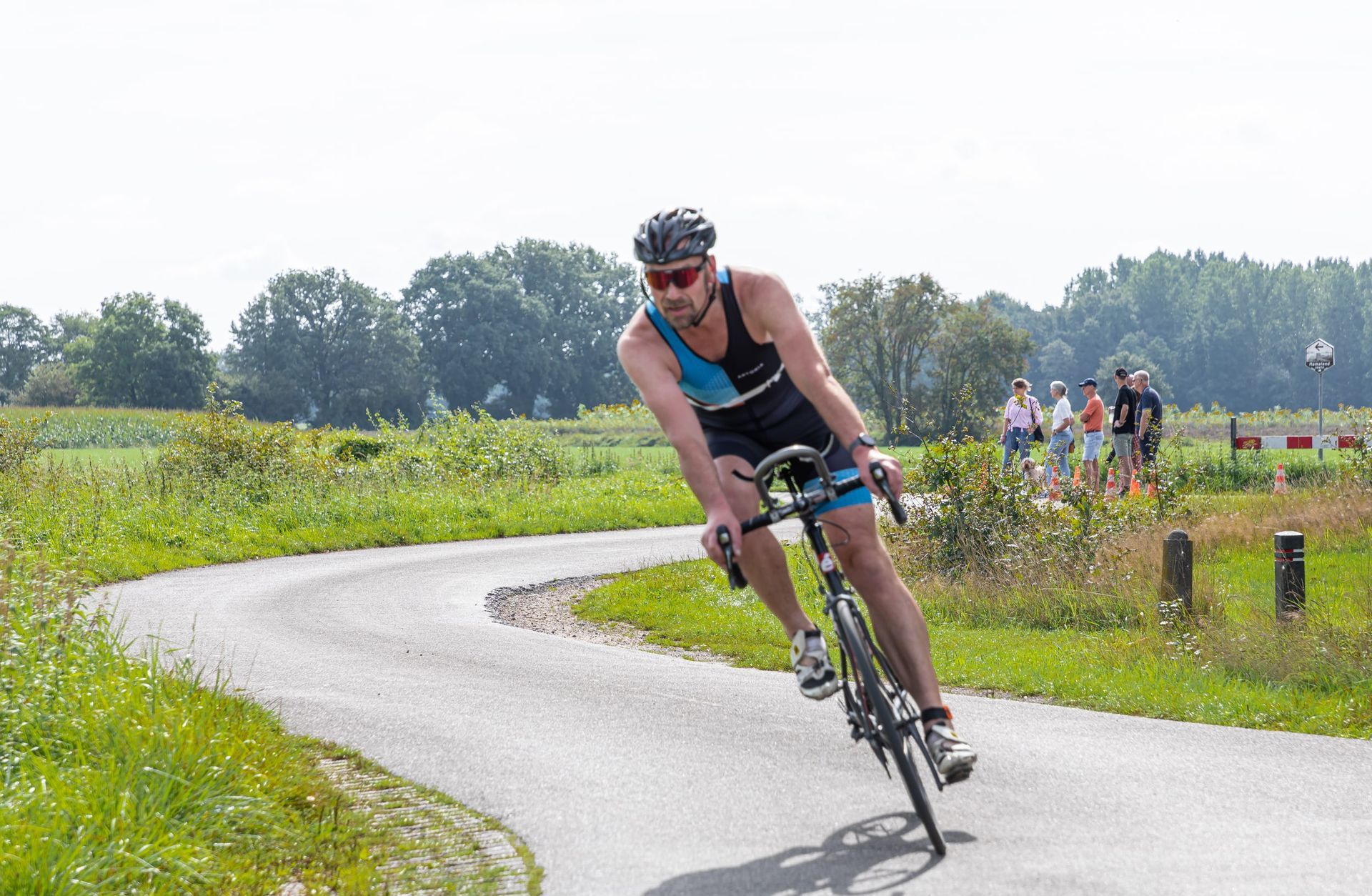 Een man fietst op een bochtige weg.
